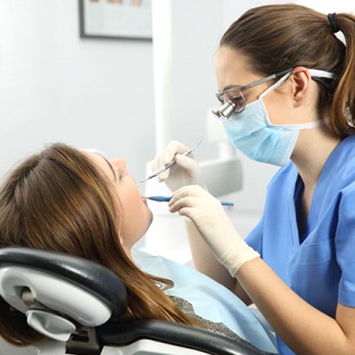 patient getting her teeth cleaned by her dental hygienist