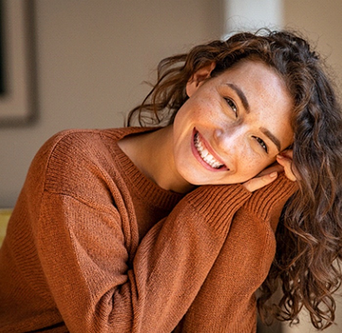 Closeup of woman in brown sweater smiling