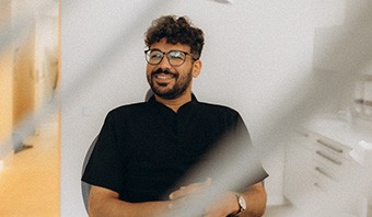 Patient with black glasses smiling in treatment chair
