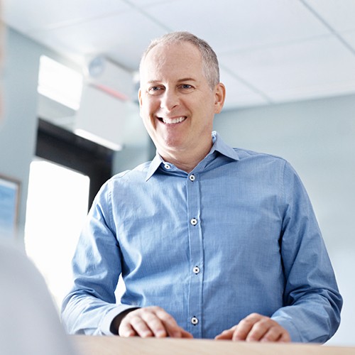 Older man checking in at reception desk