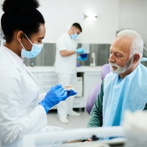 a dentist explaining how dentures work to a patient