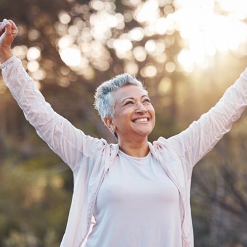 a woman smiling while enjoying the outdoors