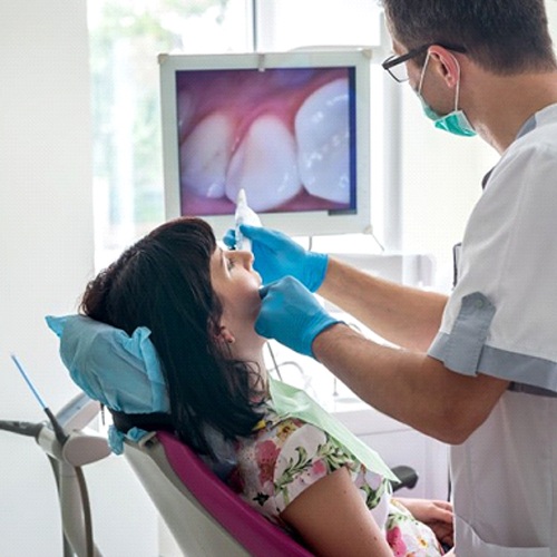 dentist examining a patient’s mouth with an intraoral camera