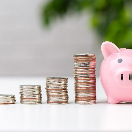 Pile of coins next to a piggy bank