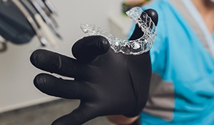 Dentist holding a clear aligner