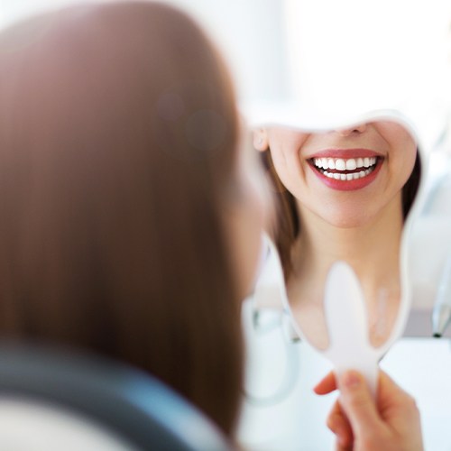 Woman looking at smile in mirror