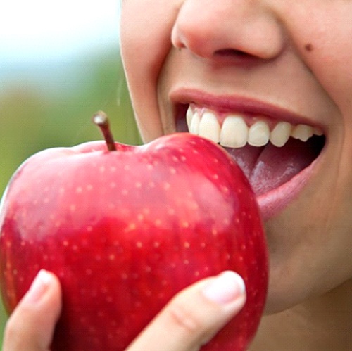 close up person eating an apple 