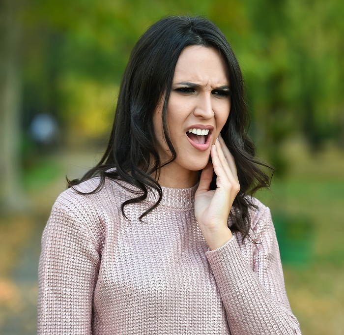 Woman in pain holding cheek