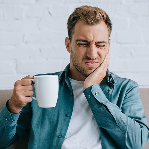 Man in pain holding cheek