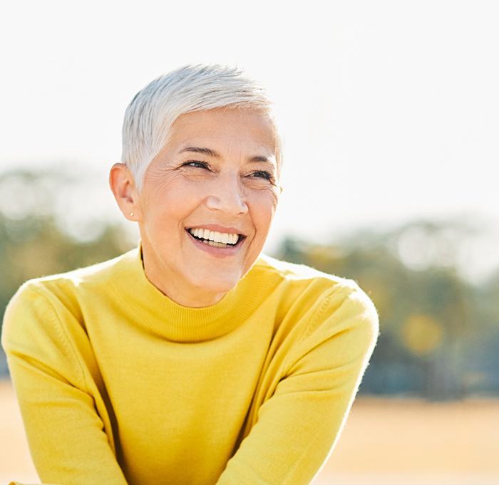 a woman in Indian Land smiling with implant dentures