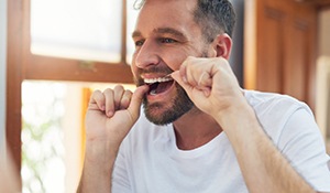 A man flossing his teeth