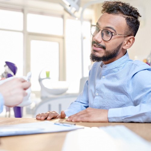 young man discussing paying for full mouth reconstruction   