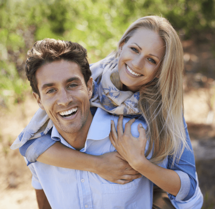 Smiling man and woman outdoors