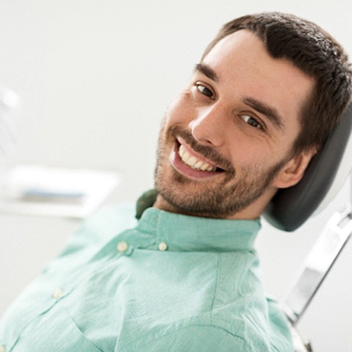 Man in dentist’s chair smiling at camera