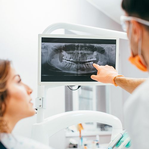 Dentist and patient looking at digital x-rays