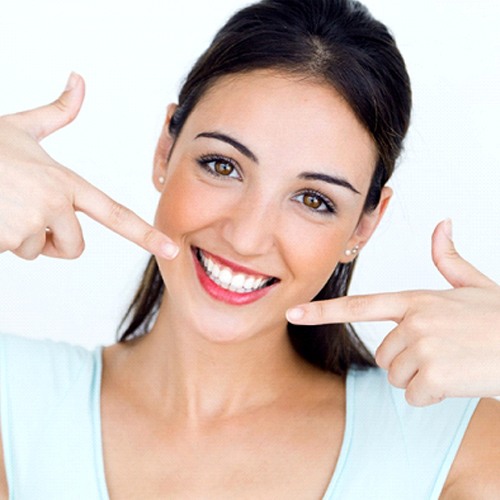 woman pointing to her perfect smile