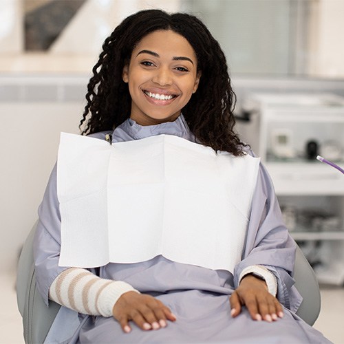 Woman sitting in dental chair smiling
