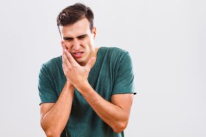 man in green shirt with toothache who needs emergency dentist in Indian Land
