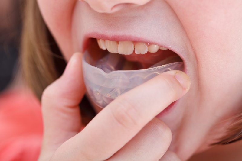 person putting in dental mouthguard