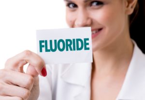 Woman holding fluoride cards