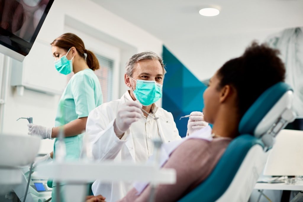 dentist preparing to work on patient’s teeth